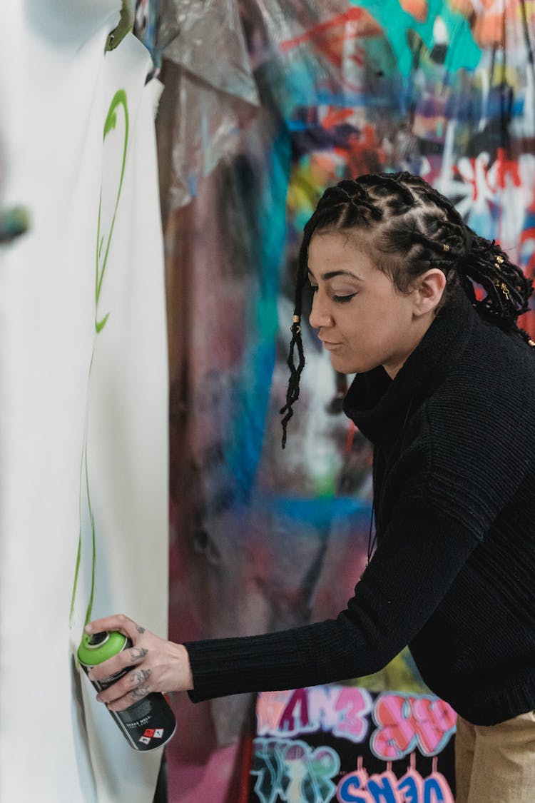 Woman Spraying Paint On Paper 