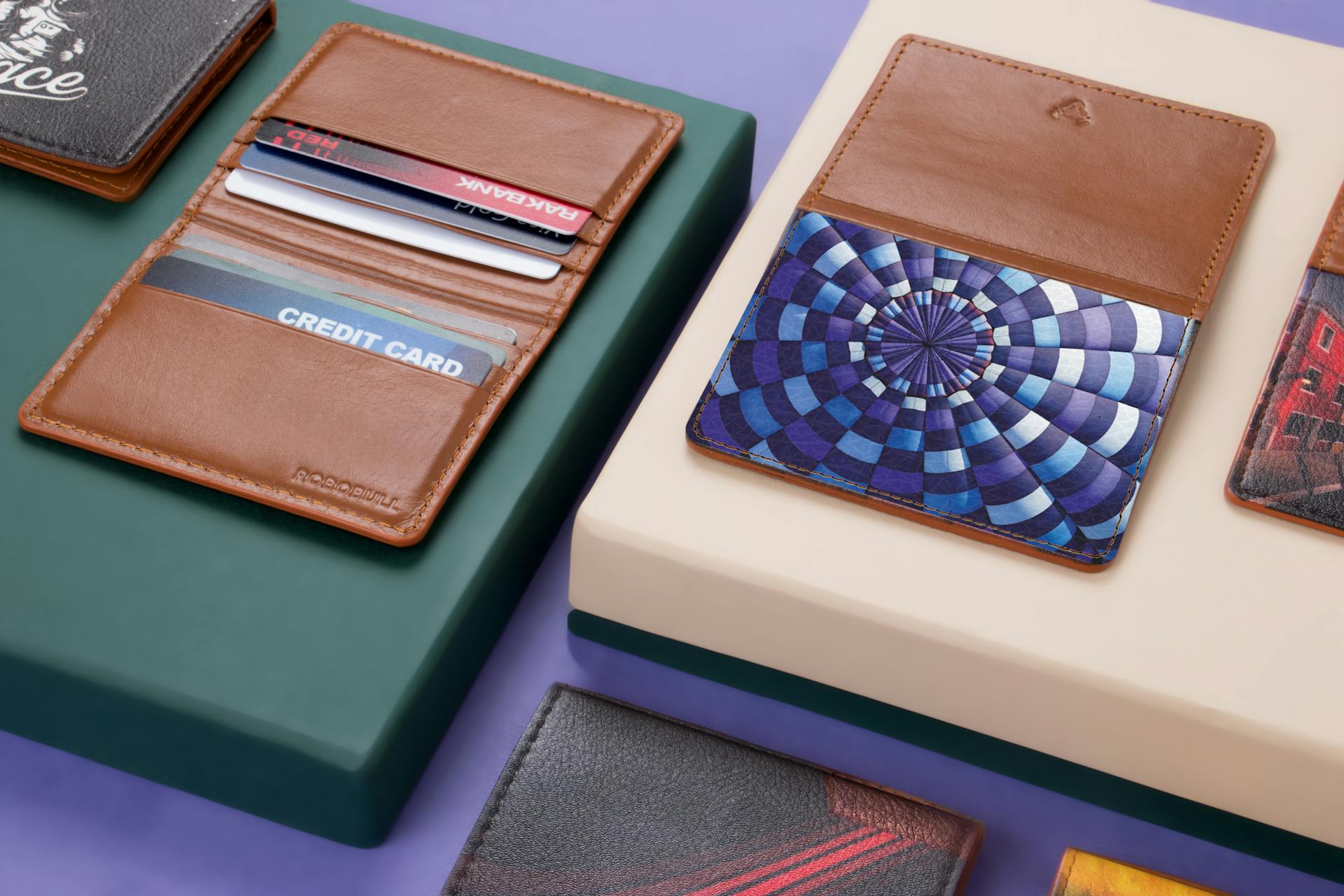 Close-up of assorted leather wallets and cardholders on a modern violet and green background.