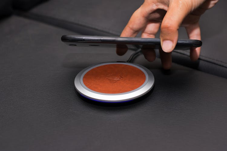 Close-up Of Person Putting Smartphone On Wireless Charger