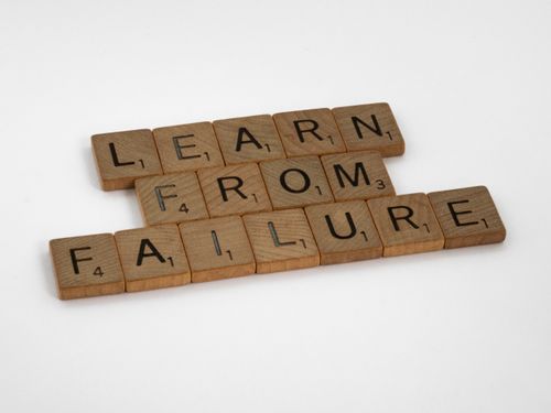 Free Wooden Scrabble tiles spelling 'Learn from Failure' on a white background, promoting resilience. Stock Photo