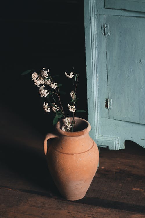 Ceramic vase with flowers on floor