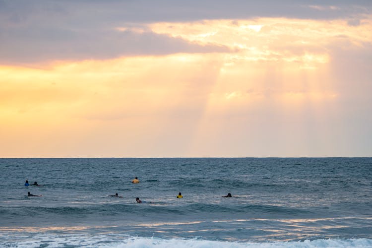 Seascape Of Wavy Sea With Swimming People Under Rays Of Sun