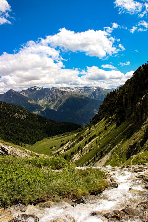 Free Mountain Valley Under Blue Sky with White Clouds Stock Photo