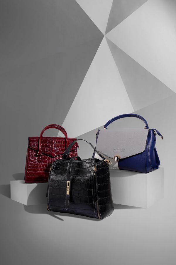 Designer handbags displayed on a studio backdrop