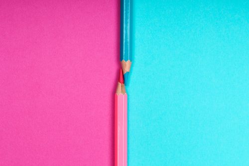 Free Close-up of sharpened colored pencils on a vibrant pink and blue background, showcasing creativity and contrast. Stock Photo