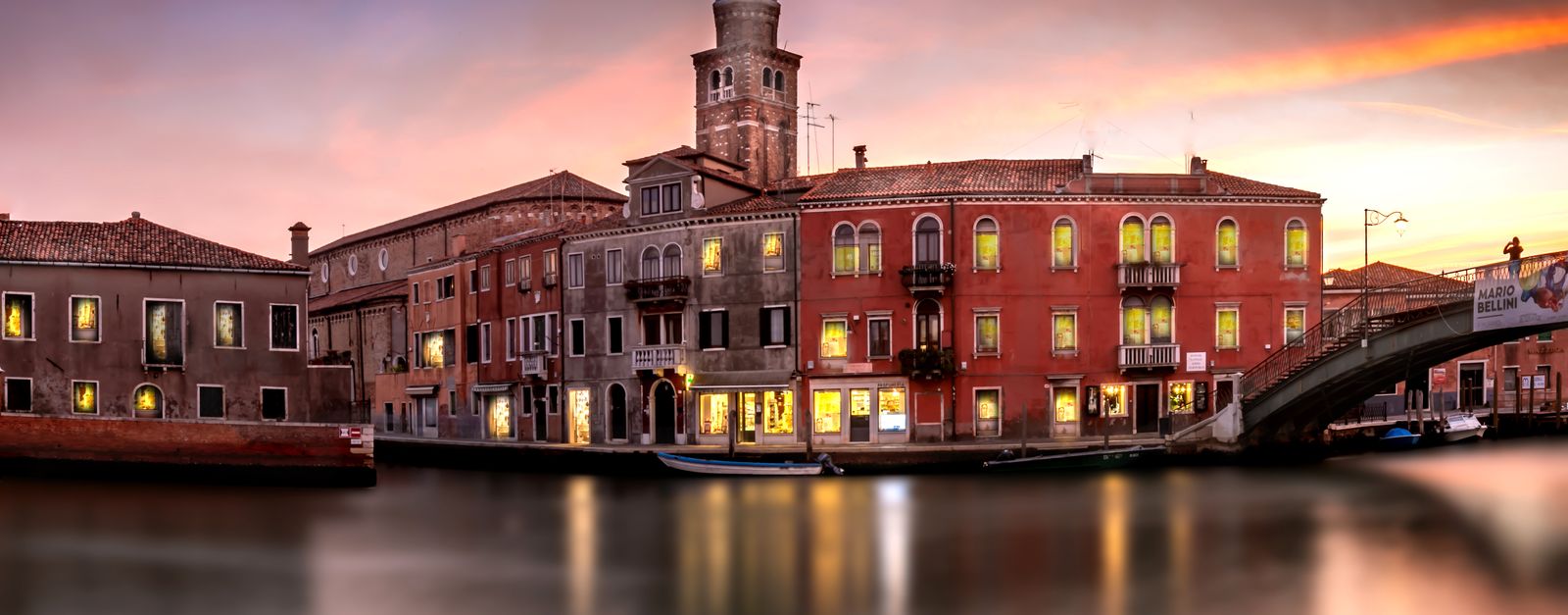 Beautiful sunset over a canal with historic buildings in Venice, Italy.