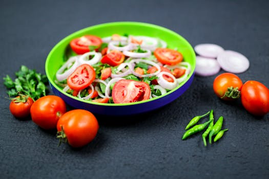 Delicious fresh vegetable salad with tomatoes, onions, and green chilies on a colorful plate.