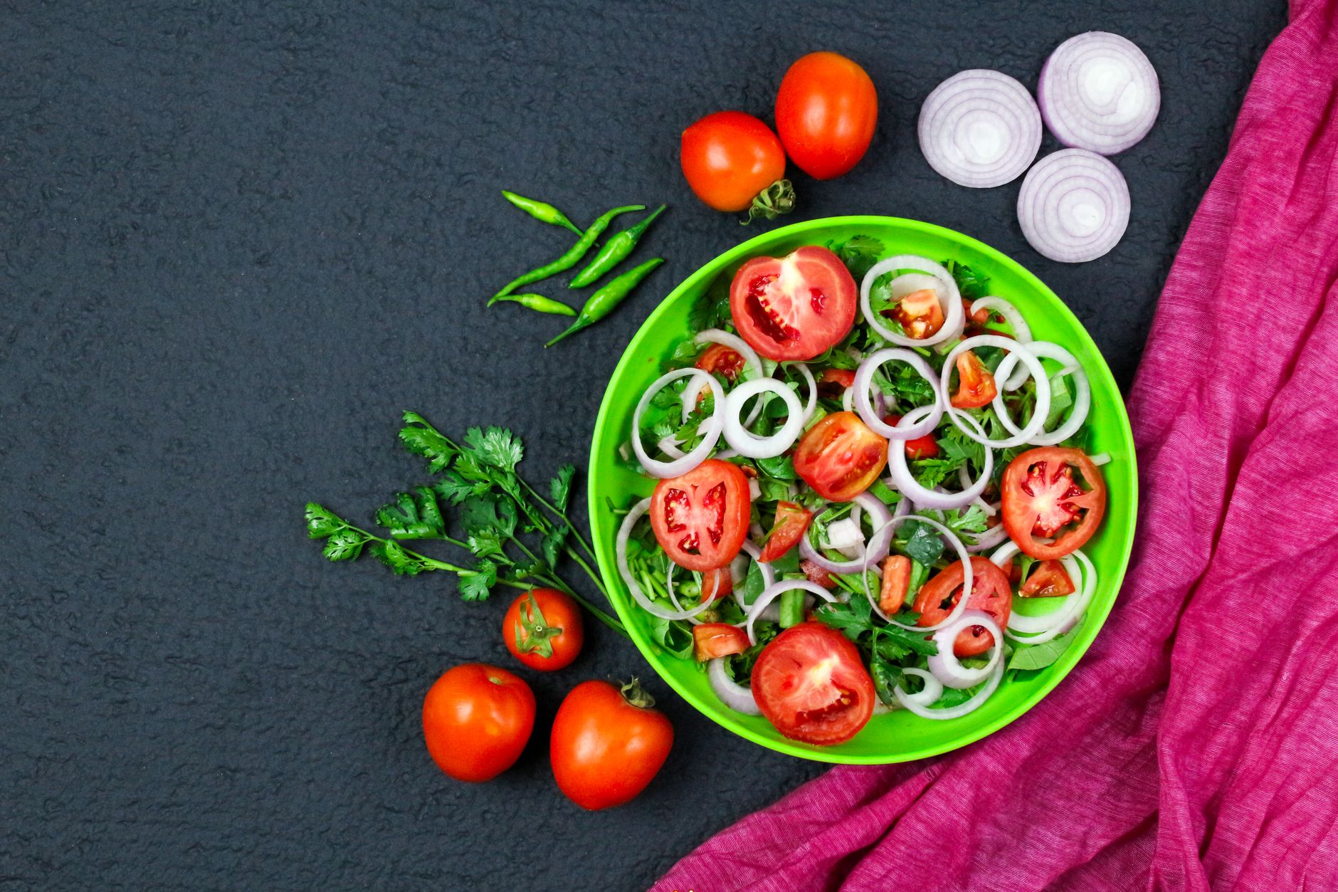 Fresh green bean salad with tomatoes and onions in white bowl