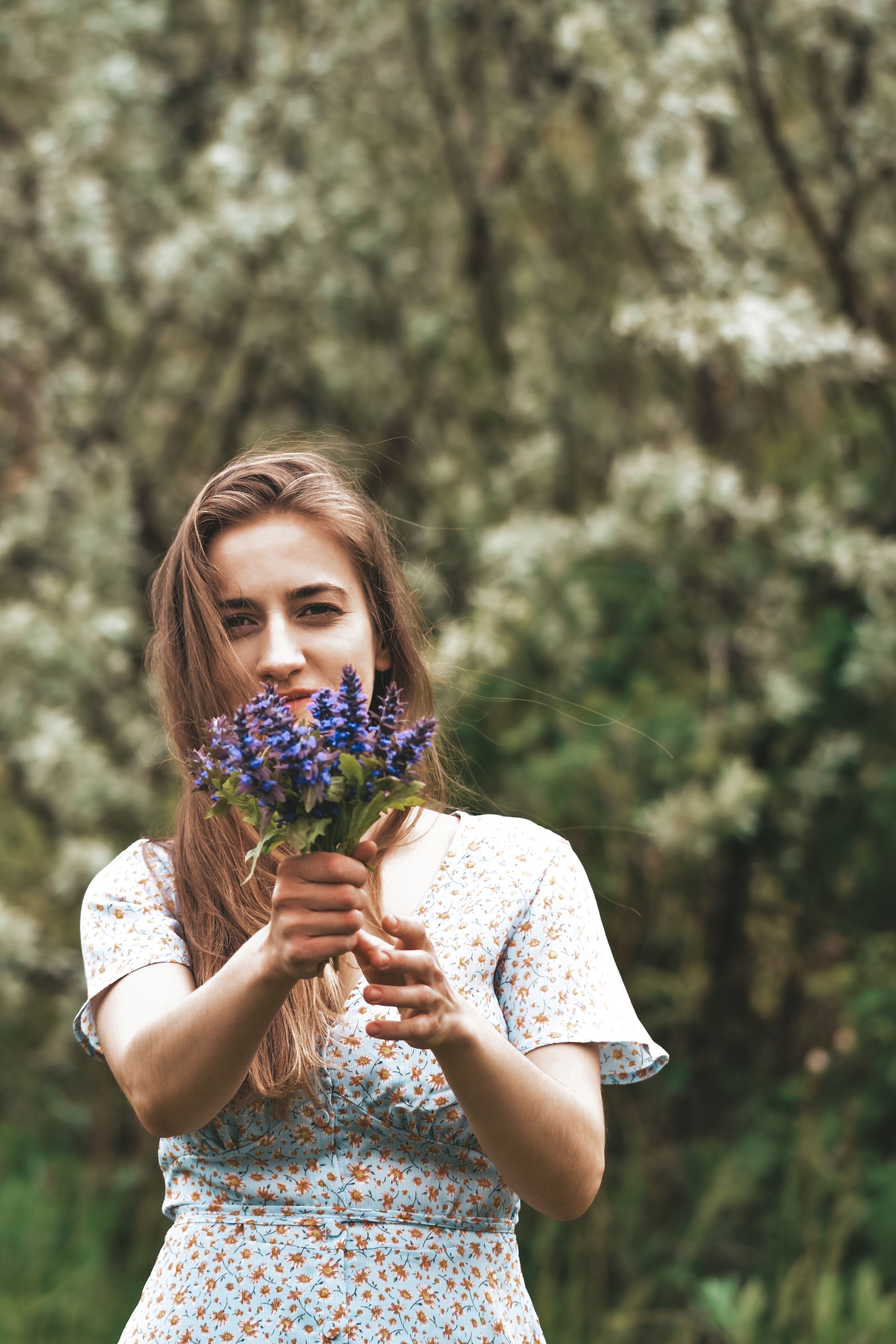 Woman in Floral Dress Holding Flowers · Free Stock Photo