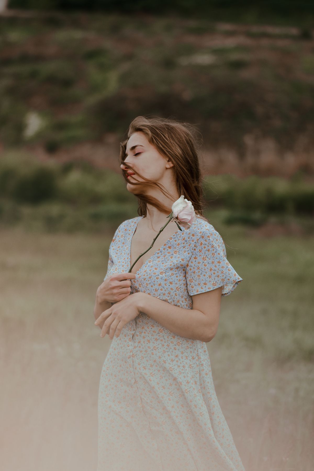A woman in a floral dress holding a flower — romantic delicate florals
