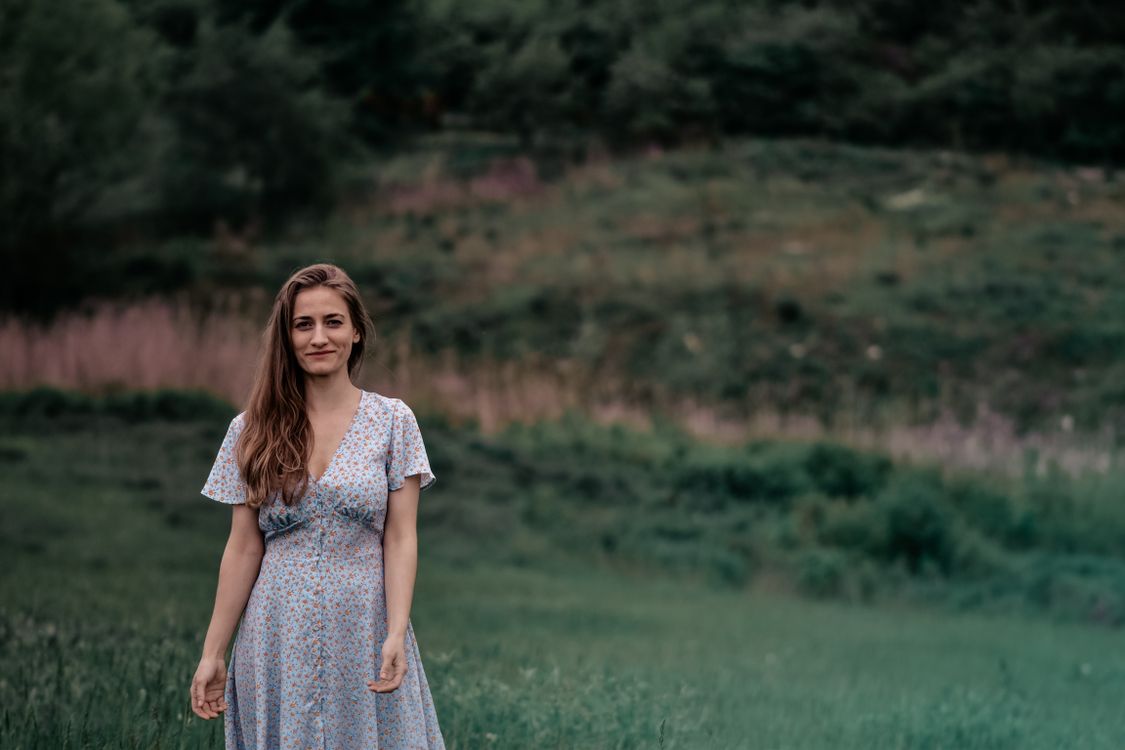 Beautiful Woman in Floral Dress Standing on a Grassy Field · Free Stock ...
