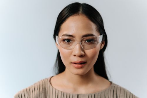 Free Close-up portrait of a woman wearing clear protective glasses on a white background. Stock Photo