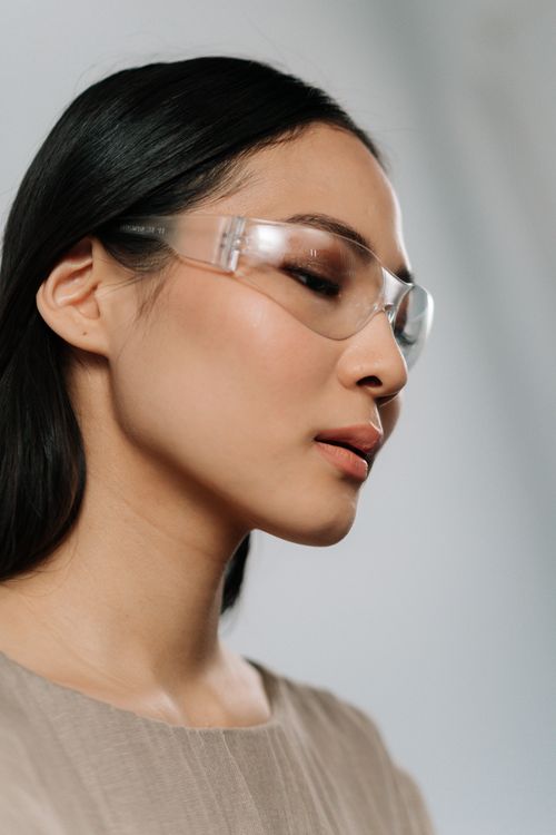 Free Close-up side profile of an Asian woman wearing modern eyeglasses against a soft background. Stock Photo