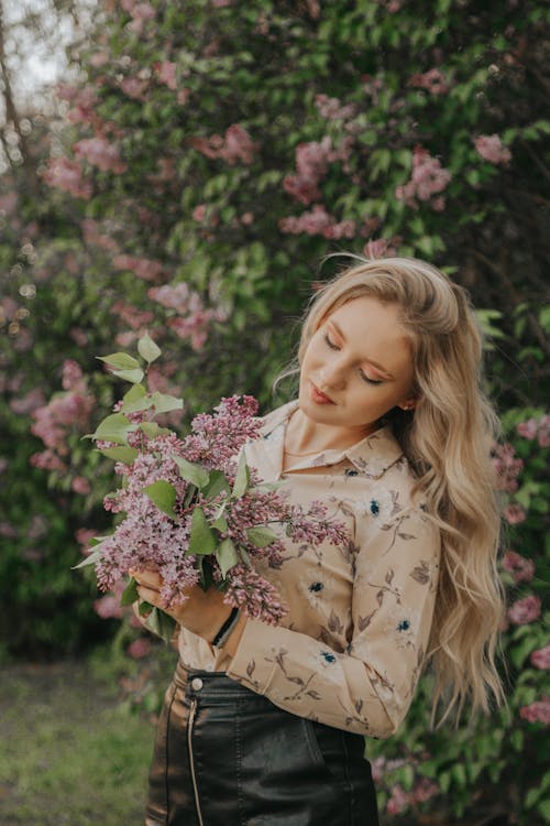 A Blonde-Haired Woman in Floral Long Sleeves Holding Bunch of Flowers