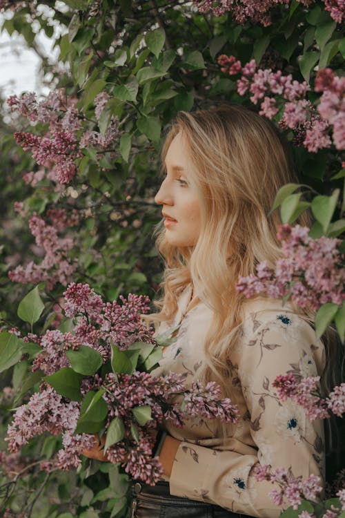 A Blonde-Haired Woman in Floral Long Sleeves Holding Bunch of Flowers