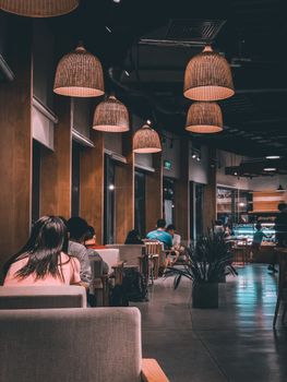 A modern restaurant interior with warm lighting and people dining in a relaxed ambiance.