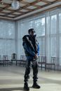 Man in Blue Jacket and Black Pants Standing on Brown Wooden Floor