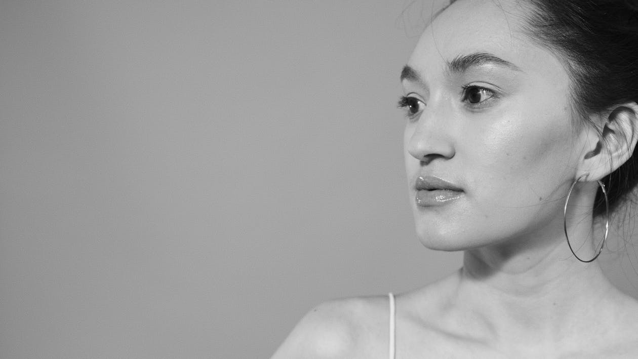 Grayscale Photo of a Woman with a Hoop Earring Looking Away