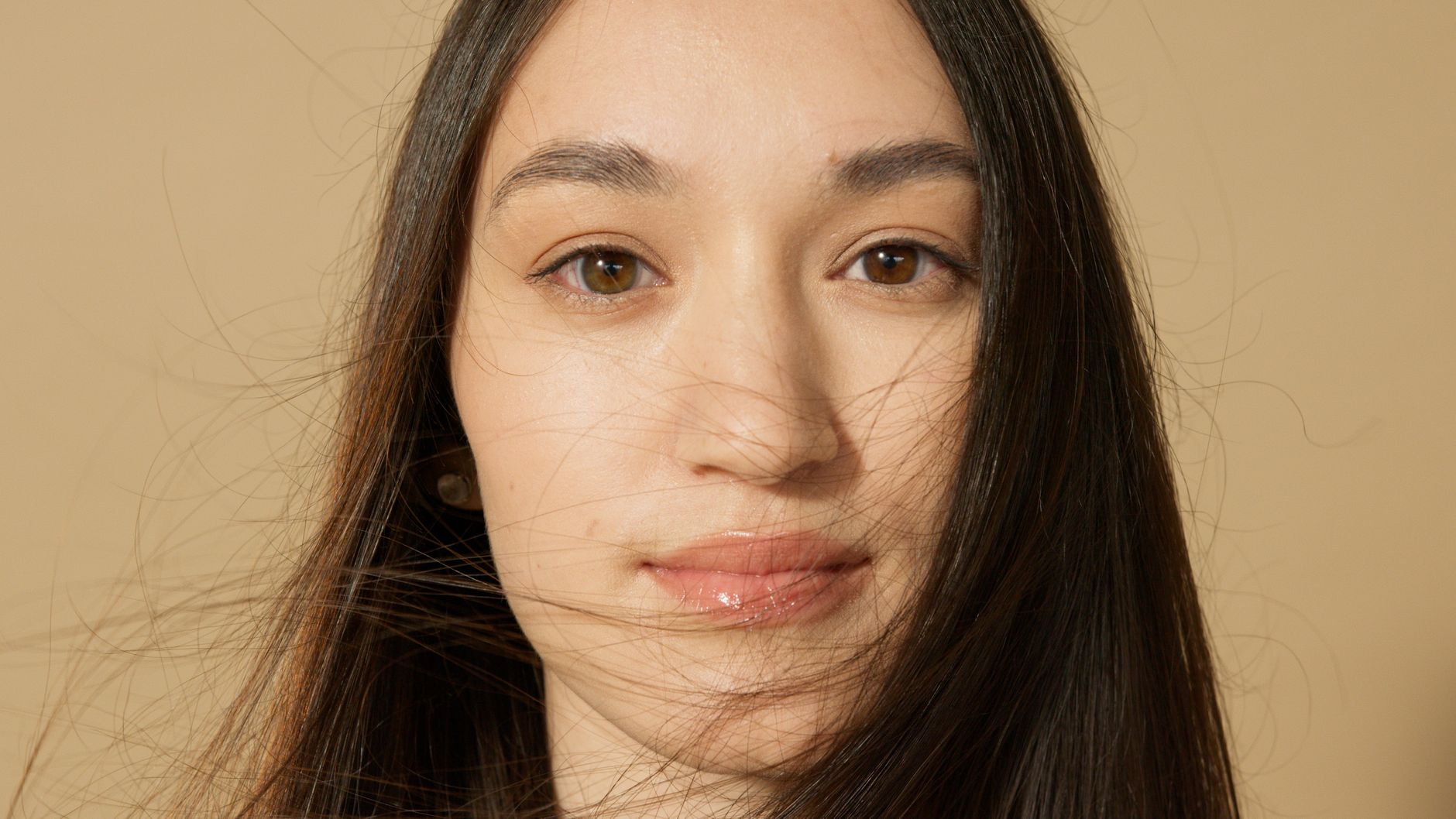 Detailed and intimate close-up portrait of a woman with long hair and a serene expression.