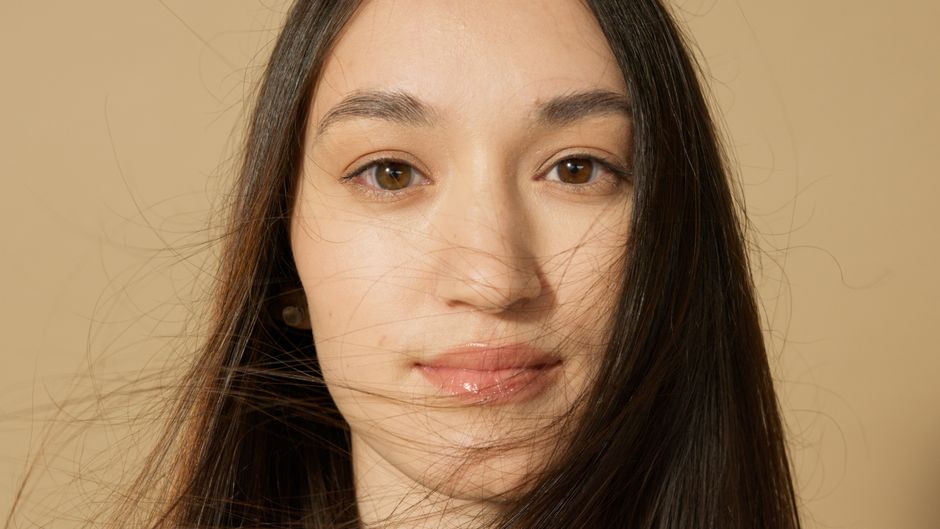 Detailed and intimate close-up portrait of a woman with long hair and a serene expression.