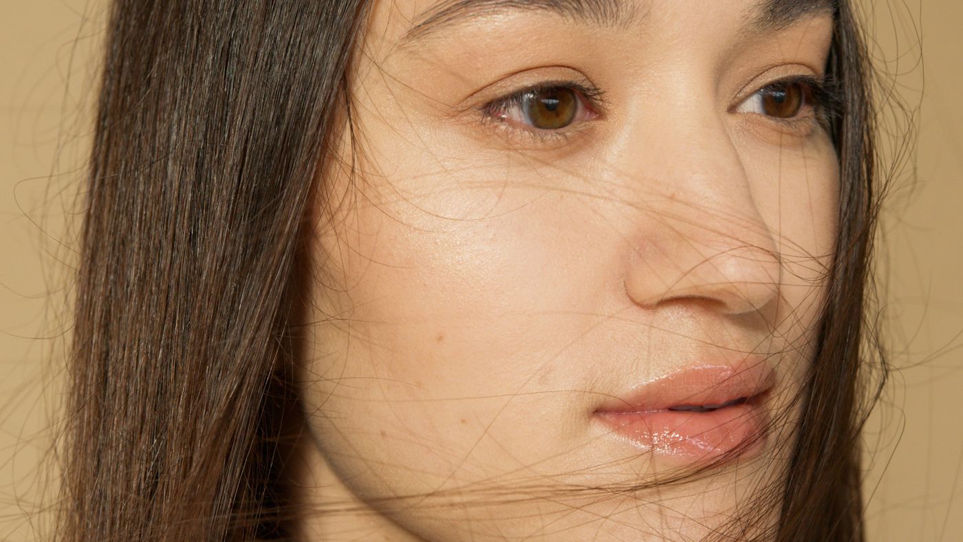 Close-up portrait of a woman with clear skin and softly lit hair — photo by Artem Podrez on Pexels