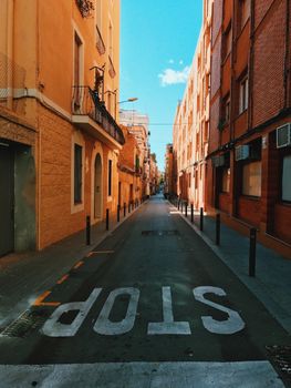 Empty colorful street in Barcelona with stop sign and traditional buildings.