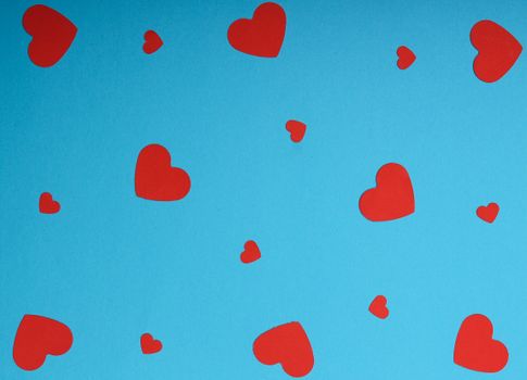 Scattered red heart shapes on a vibrant blue background, perfect for romantic designs.