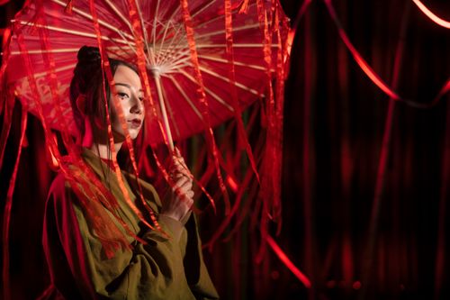 Free A captivating portrait of a woman in a kimono holding a vibrant red umbrella, symbolizing Japanese culture and tradition. Stock Photo