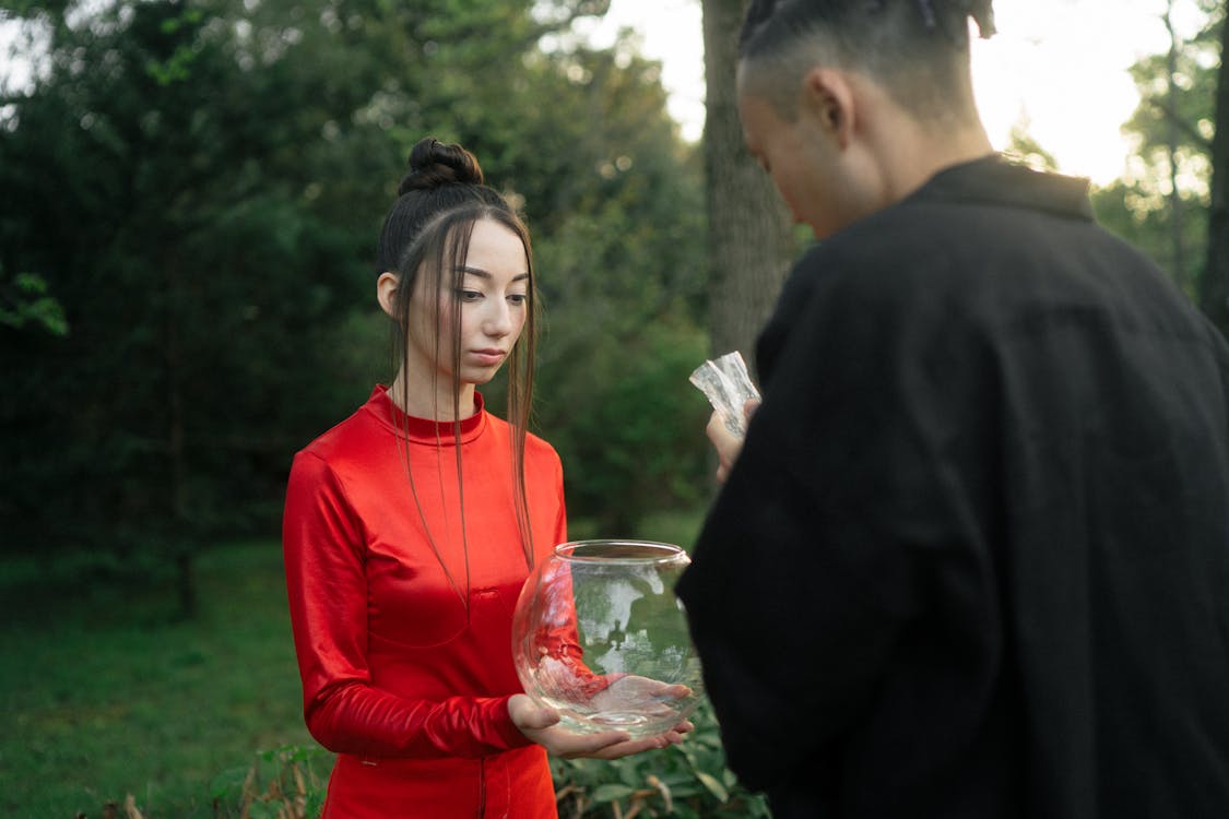 Free Woman In Red Dress Holding A Fish Bowl Stock Photo