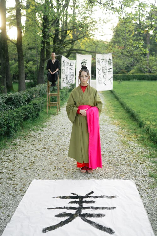 Free Woman In Green Kimono Standing On A Pathway Stock Photo