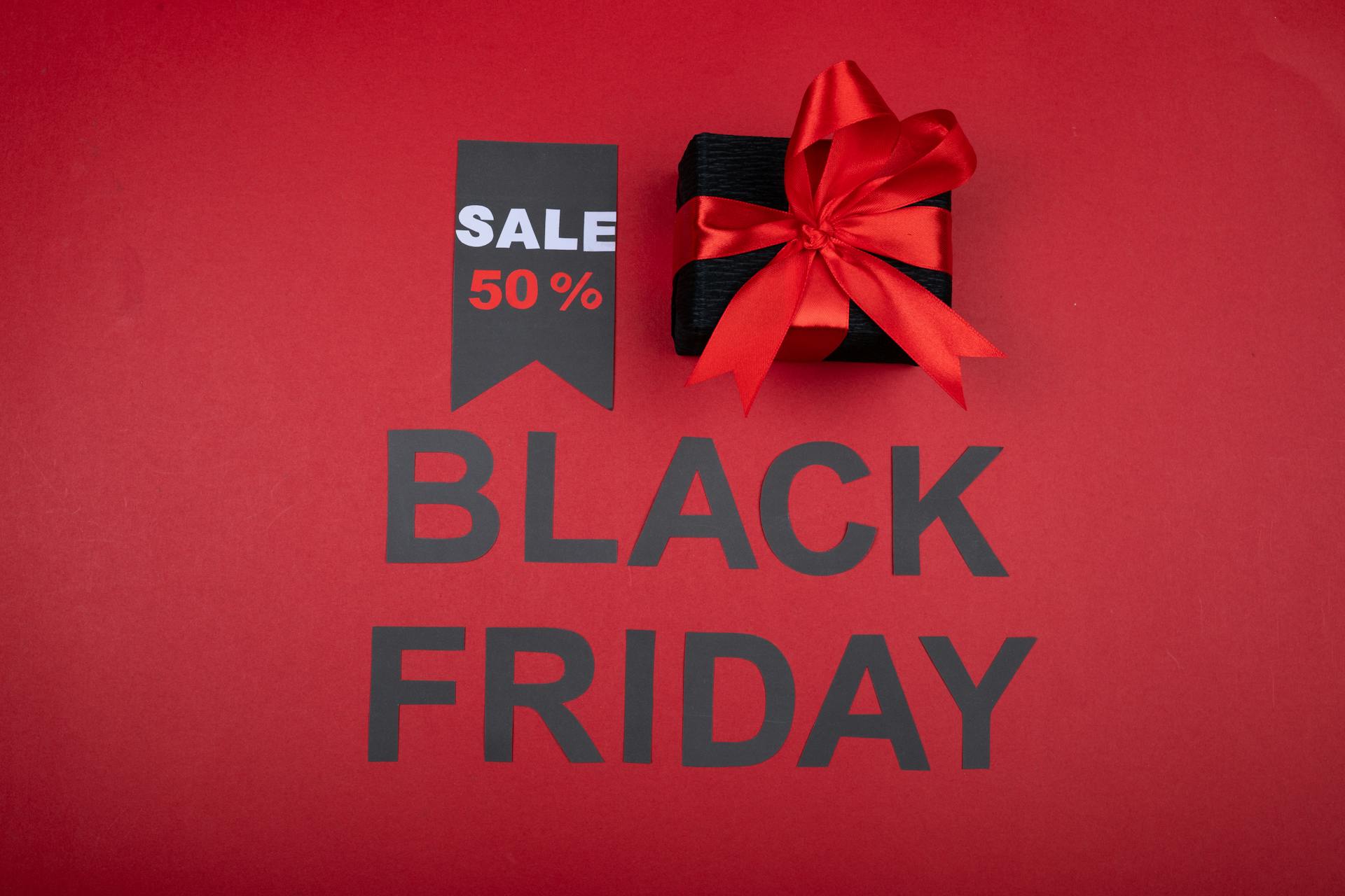 Celebrate Black Friday with a 50% off deal featuring a gift box and vibrant red theme.