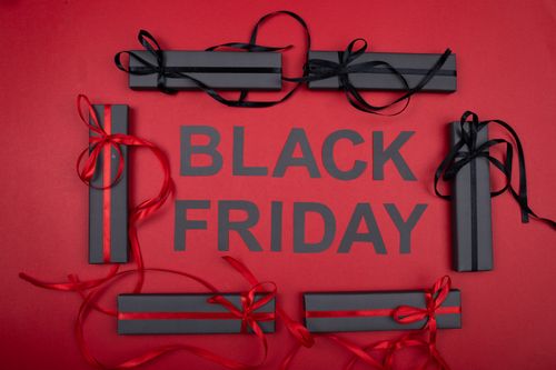Free Black Friday gift boxes with ribbons on a red background, perfect for holiday promotions. Stock Photo