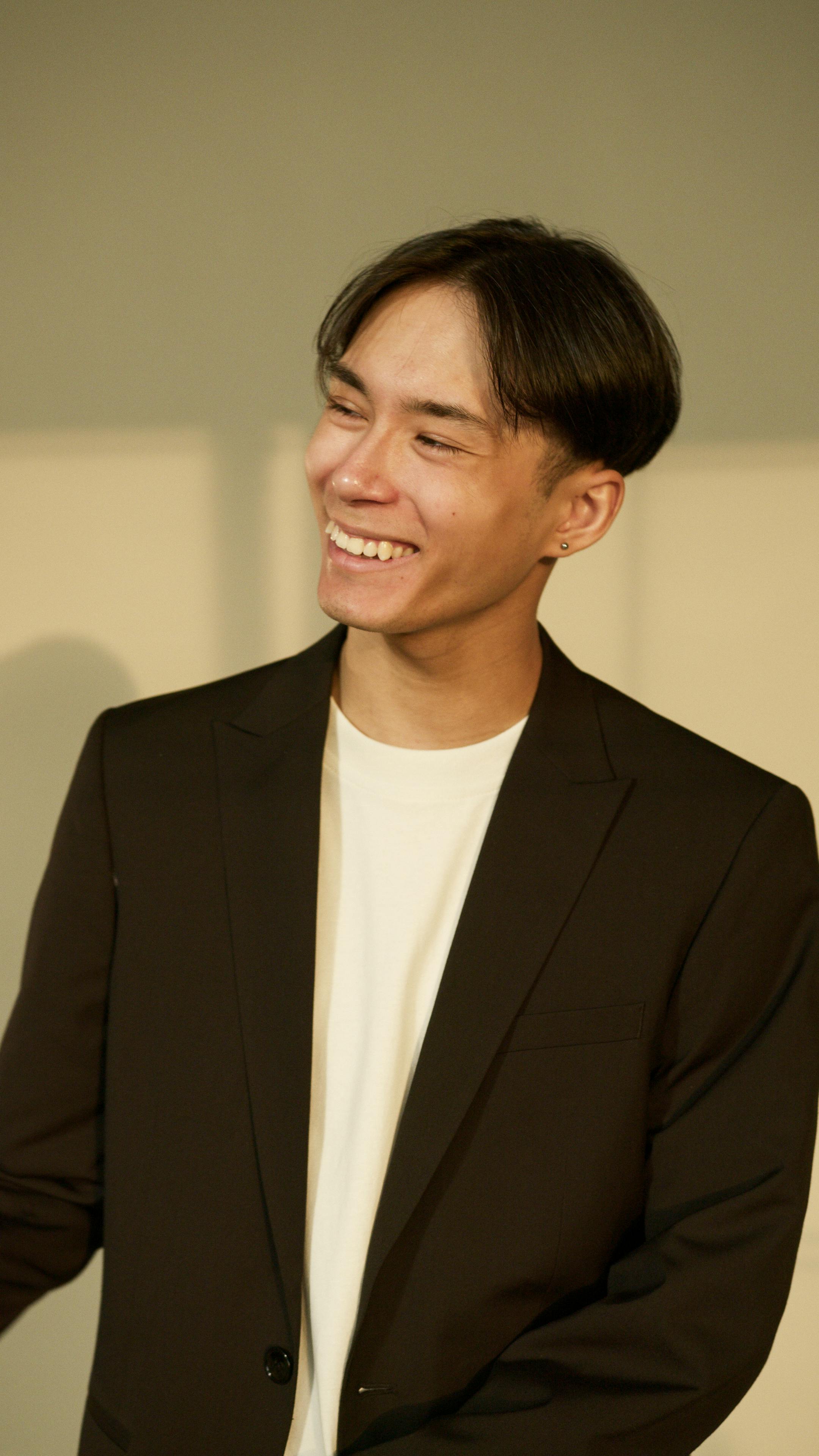 man wearing a black blazer smiling