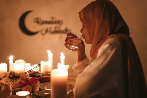 Woman in Hijab Holding a Clear Drinking Glass
