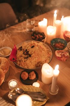 A warm, inviting Ramadan meal setting with various traditional dishes and burning candles on a wooden table.