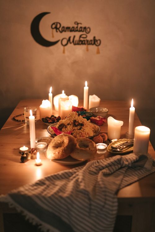 Free A cozy Ramadan iftar table with food, candles, and festive decor for a warm celebration. Stock Photo