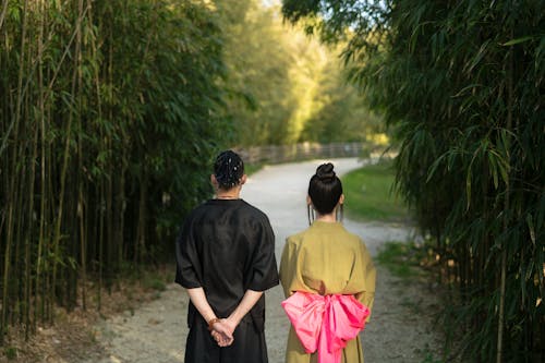 Back View Of Man And Woman Standing In An Unpaved Road