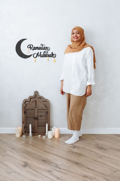 Free A woman in traditional wear smiling indoors, celebrating Ramadan. Stock Photo