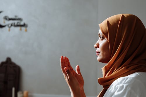 A Woman wearing Headscarf doing Praying