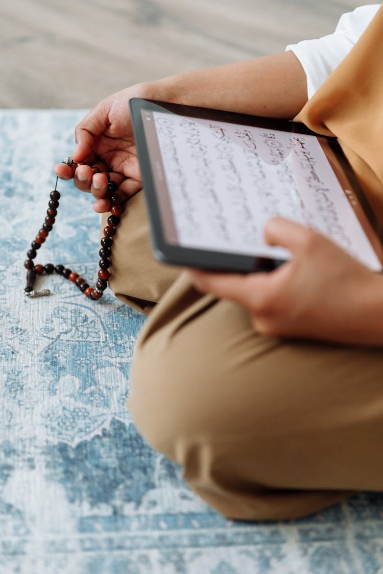 Person Using A Tablet While Praying