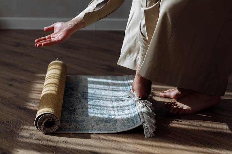 Person Rolling Out A Prayer Rug 