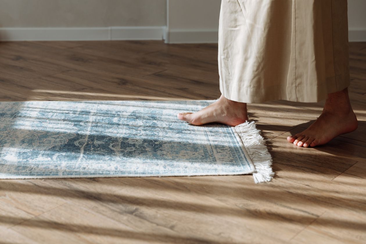 Person standing on a rug to press it flat