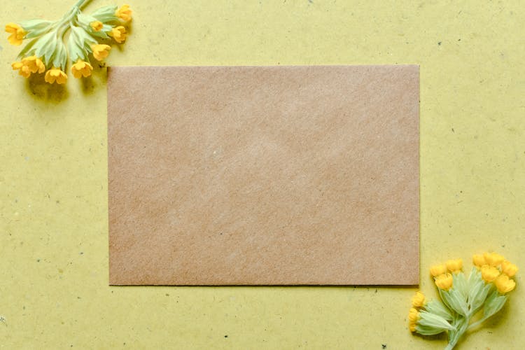 Brown Specialty Paper On Surface With Yellow Flowers