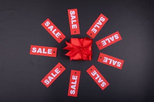Free A Gift with Red Ribbon Surrounded by Sale Texts Stock Photo