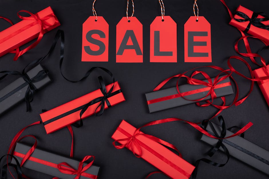 Red and black gift boxes with SALE tags on a black background, perfect for promotions.