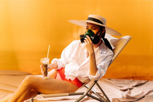 Photo of a Woman with a Hat Wearing a Respirator