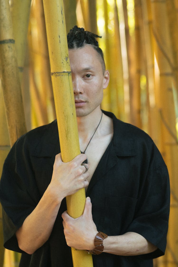 Man Holding A Bamboo Stalk