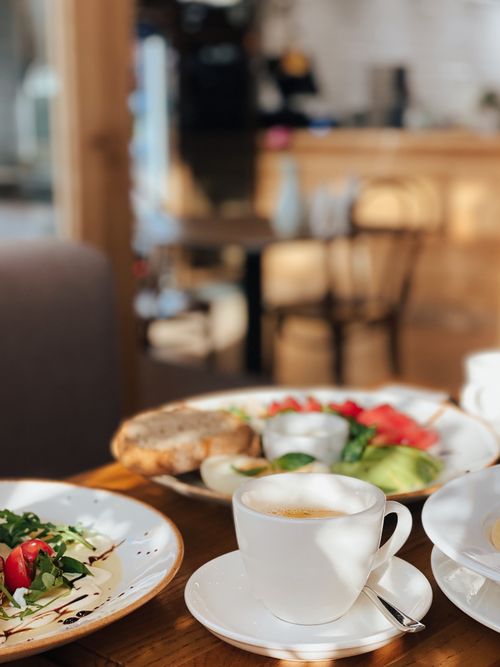 Free Inviting breakfast with coffee, fresh salad, and bread in a cozy cafe setting. Stock Photo