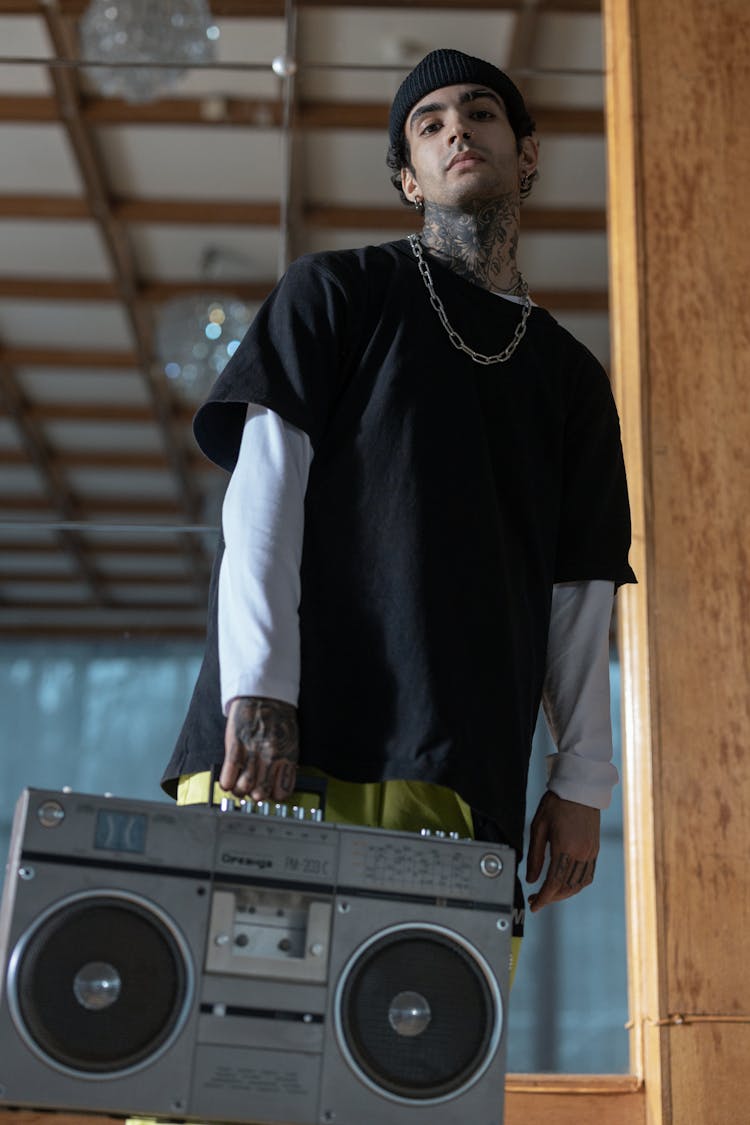 Low-Angle Shot Of A Man With A Chain Necklace Carrying A Boombox