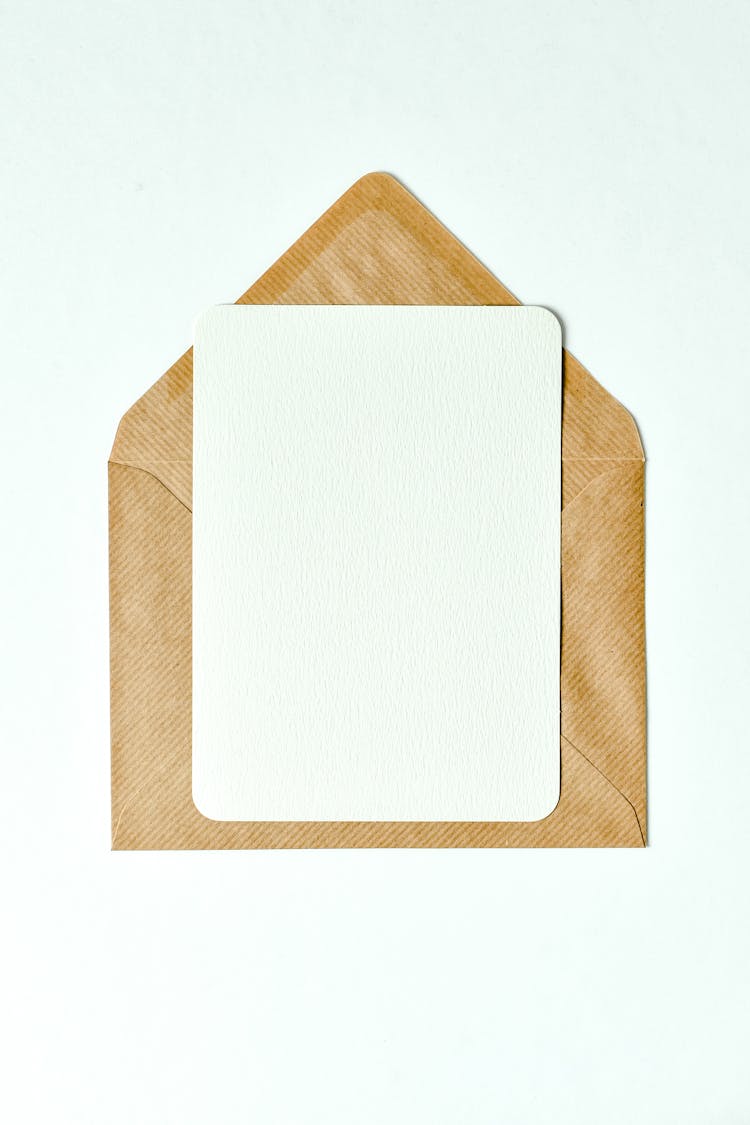 A Sheet Of Paper On Top Of A Brown Envelope